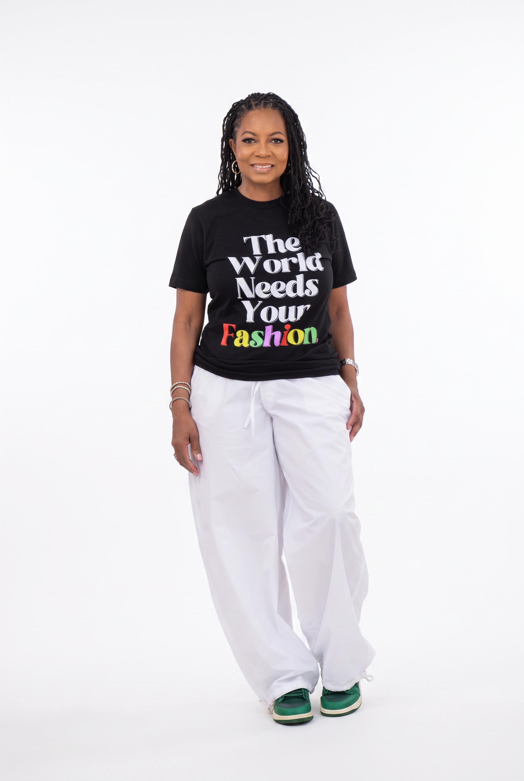 Model wearing The World Needs Your Fashion short sleeve t-shirt with white wide leg pants